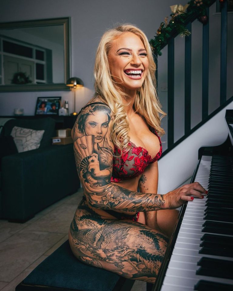 Woman with extensive tattoos playing piano.