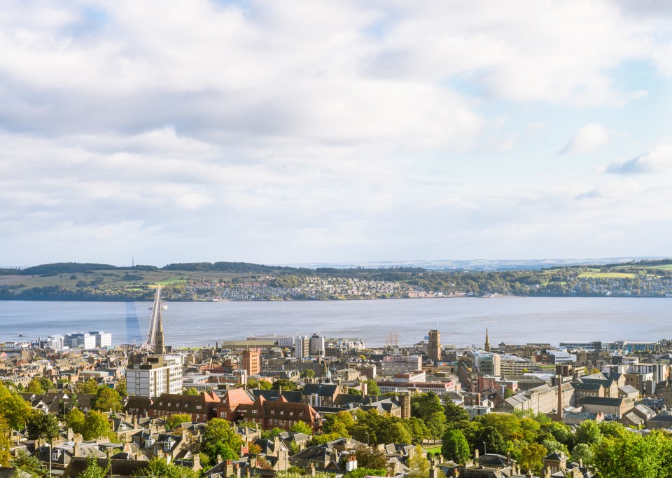 Aerial view of Dundee, Scotland, showing the city center, the Tay Road Bridge, and the Tay Estuary.