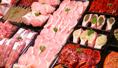 Various pork meat products are on display in a butcher shop.