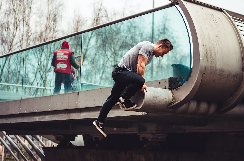 a man performing an outdoor physical activity on a modern urban bridge
