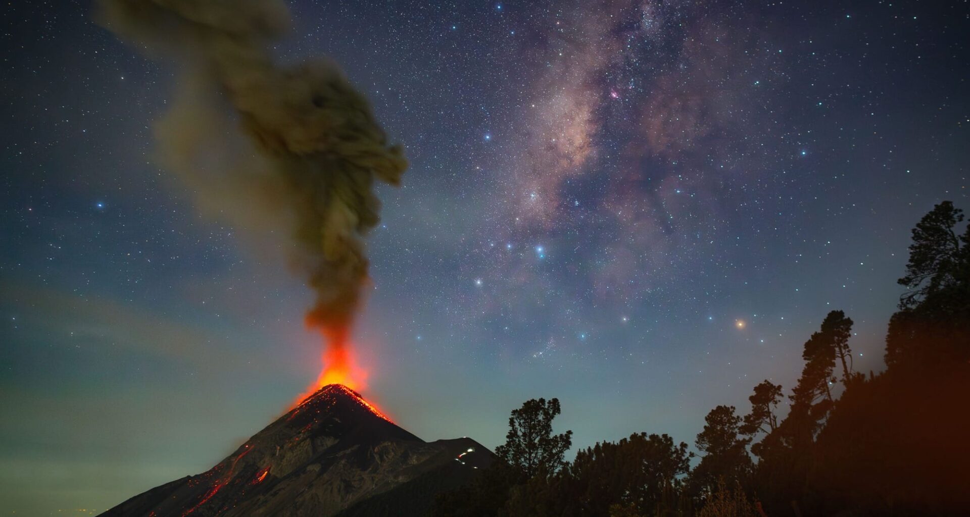 a volcano erupts beneath the milky way