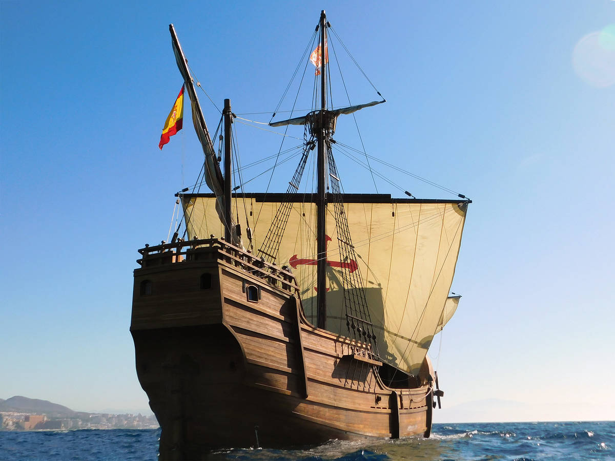 a replica of the christopher columbus ship the nao santa maria, as seen with its sails billowing while sailing across the sea