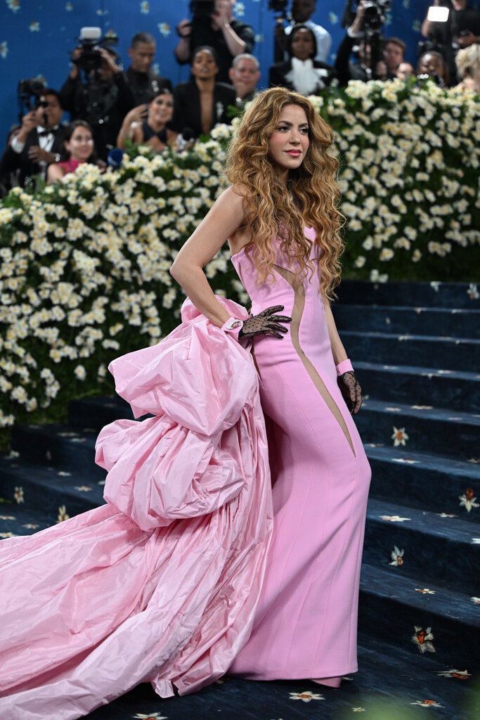 Shakira wearing a light pink dress with a voluminous train.