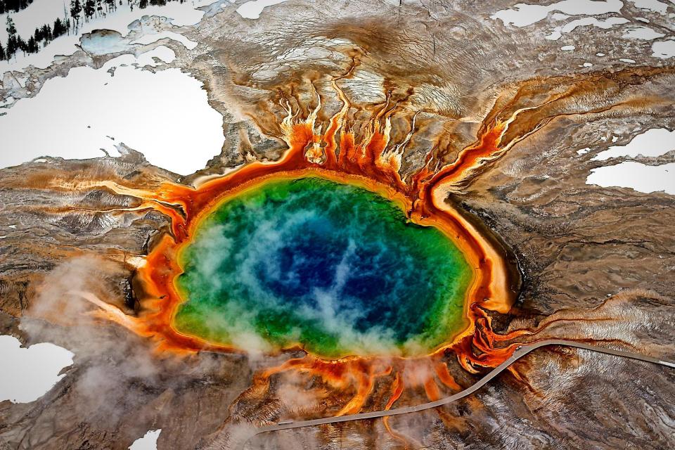 Aerial view of a geothermal area with a vibrant hot spring.