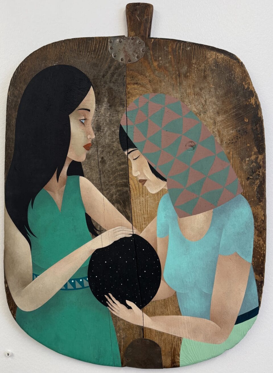a painting of two figures on an old wooden paddle or cutting board