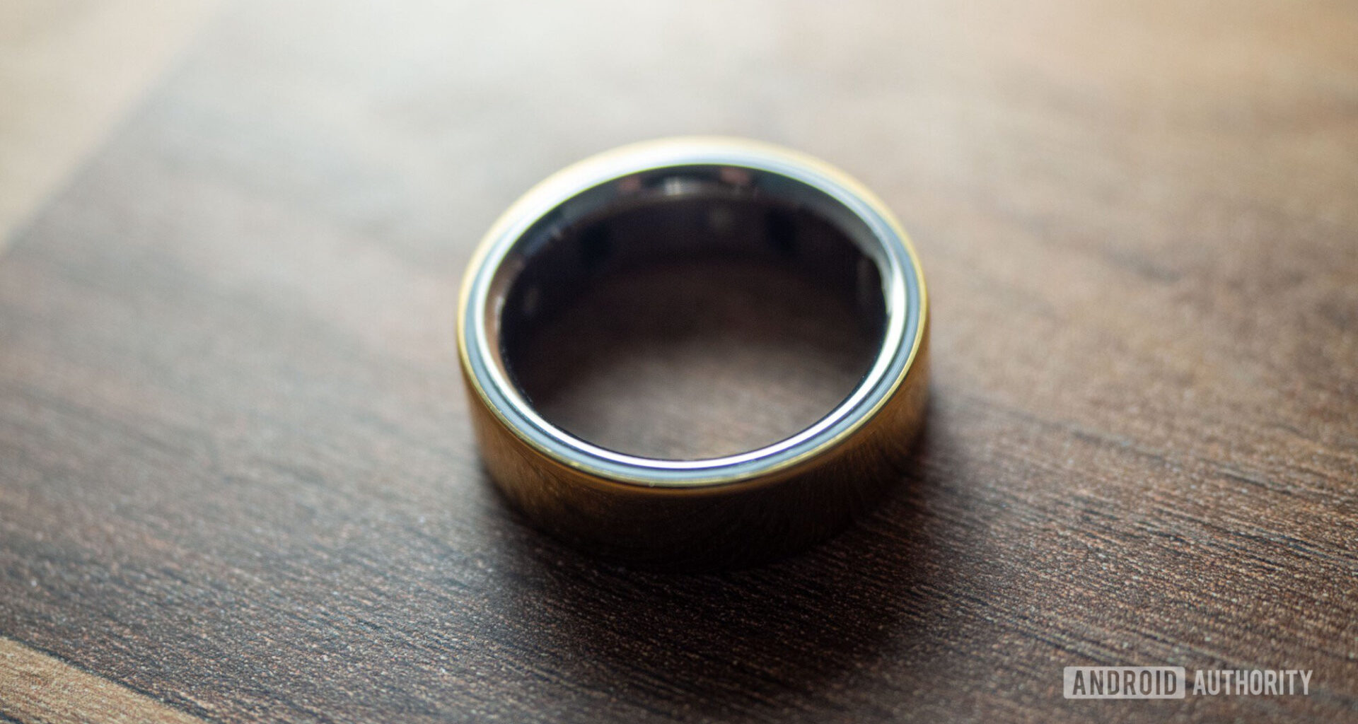 An Oura Ring 4 rests on a wooden surface