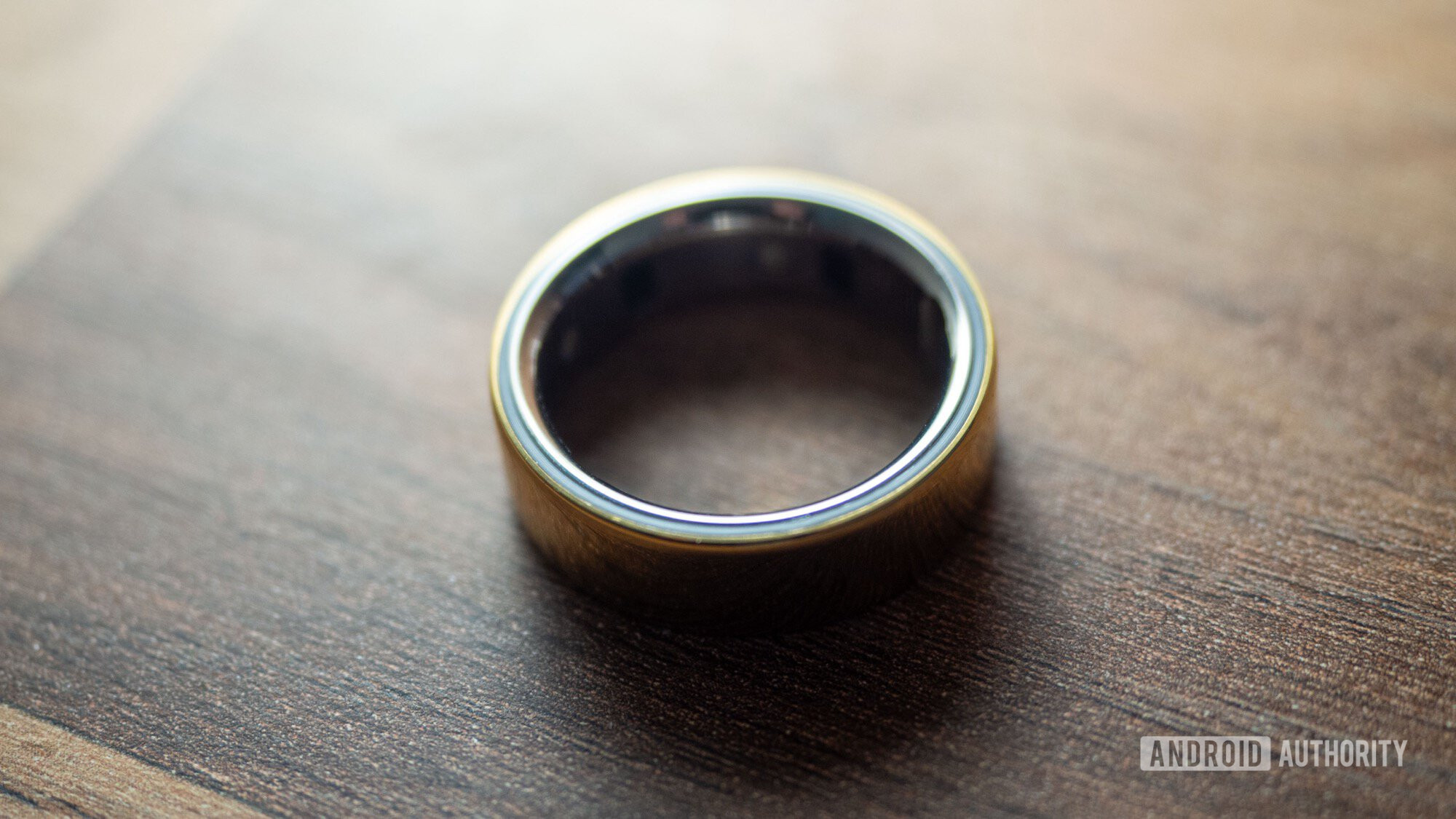 An Oura Ring 4 rests on a wooden surface