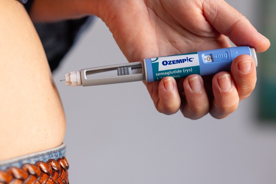 Person injecting Ozempic.