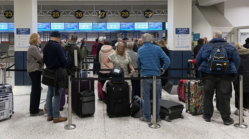 Passengers queue inside the departures area of Terminal 1 at Manchester Airport
