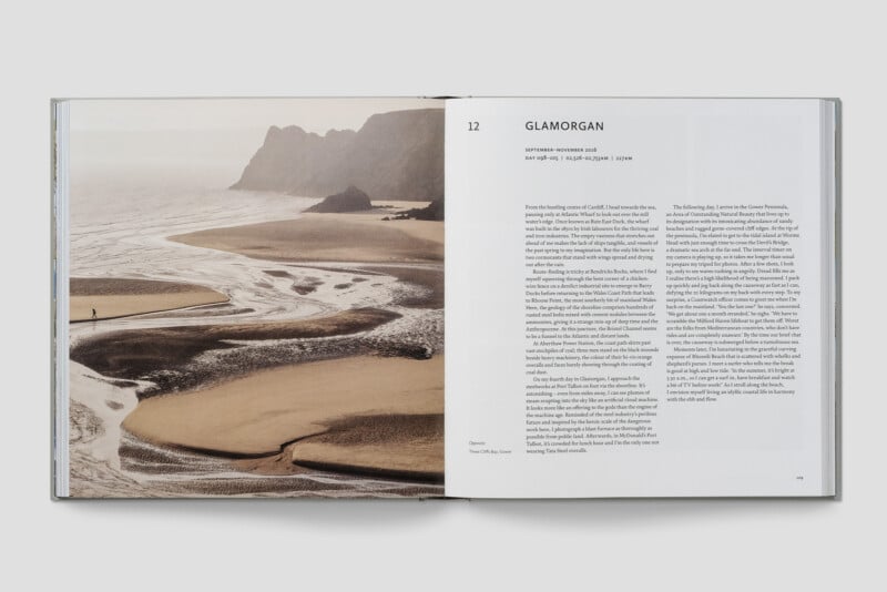 An open book displays a photograph of a coastal landscape with sandy beaches, a lone person walking, and rocky cliffs. The right page features the chapter title "Glamorgan" and two columns of text describing the location.