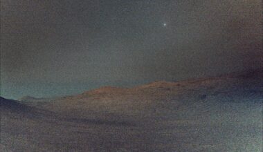 NASA's Perseverance rover captured this view of Deimos (the brightest spot in the sky), the smaller of Mars two moons, shining in the sky at 4:27 a.m. local time on March 1, 2025. The low light makes the view hazy, and the sky and ground both have a gray tint. In the distance, the crest of a crater shows Mars' signature rusty red color.