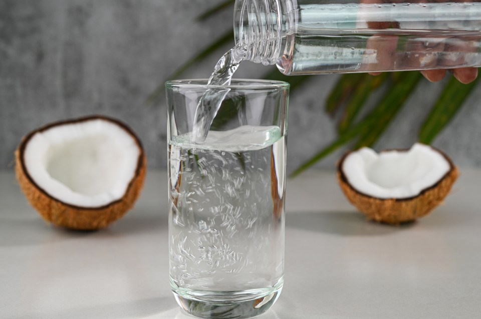 Pouring coconut water into a glass.