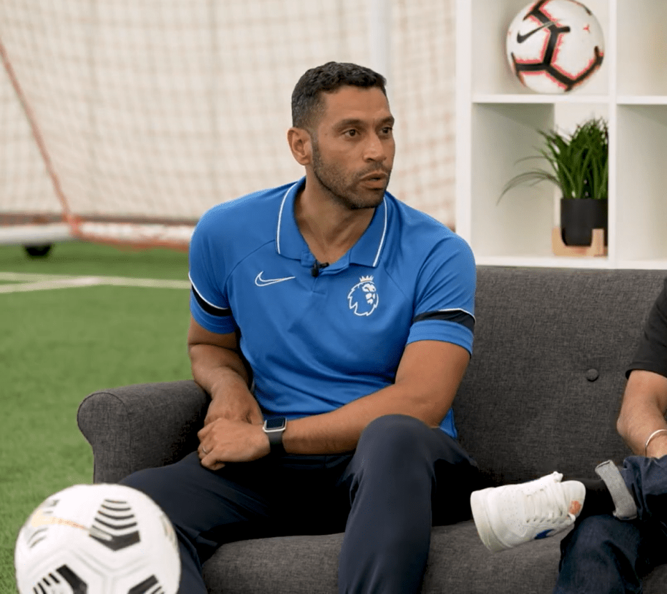 Man in Brighton polo shirt sits on couch.