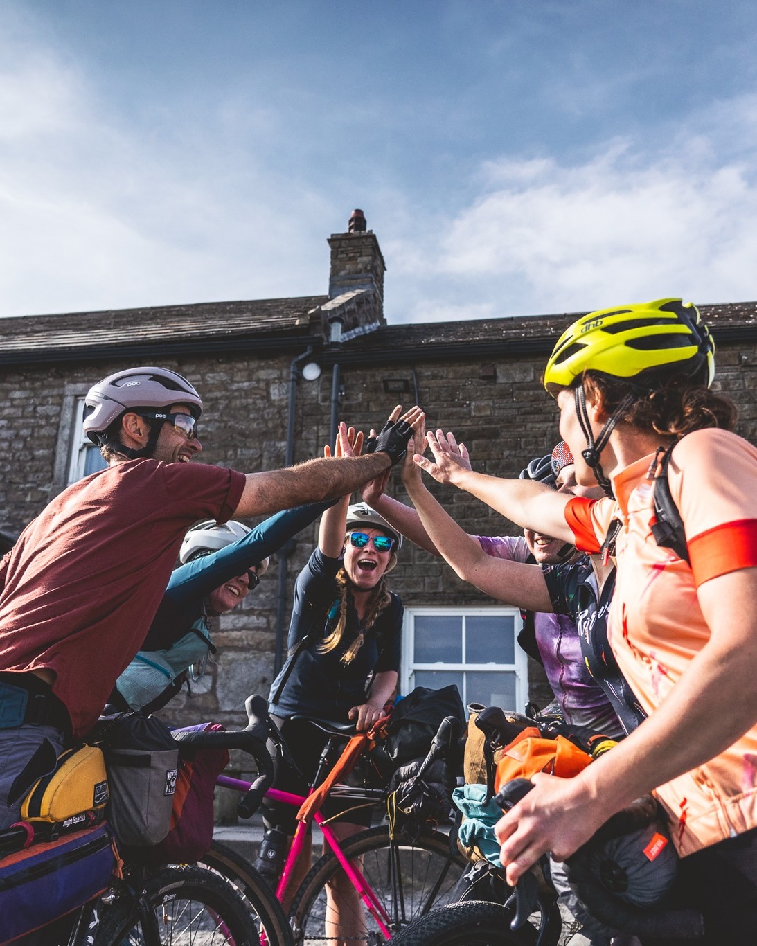 rapha bike shop manchester cyclists high fiving on bikes