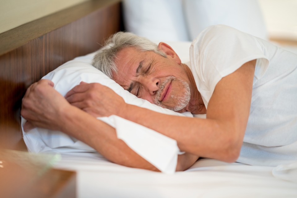 Senior man sleeping peacefully in bed.