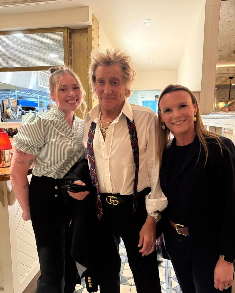 Rod Stewart with two women at a restaurant.