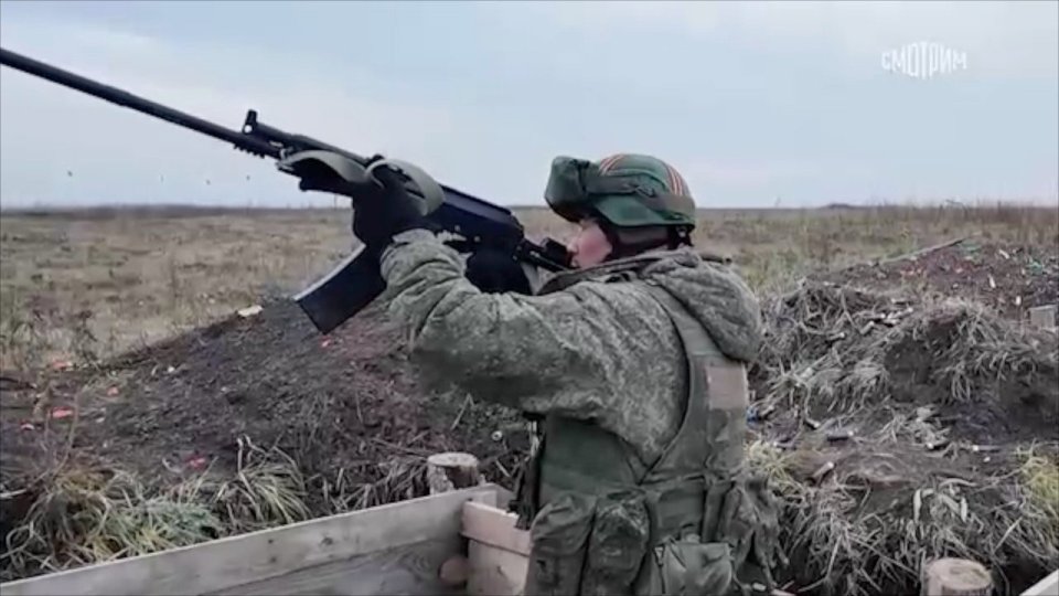 A soldier firing a rifle.