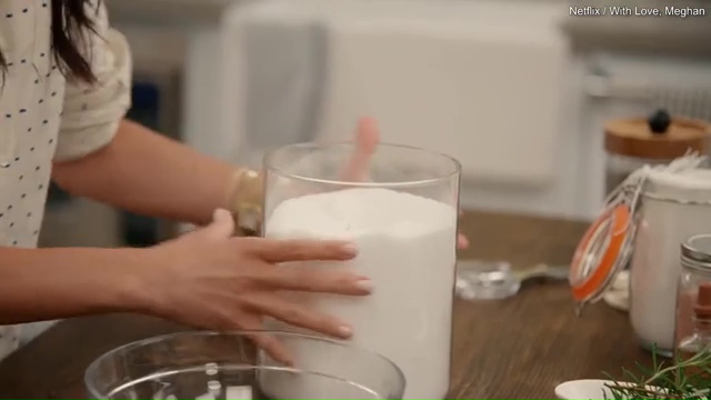Person's hands reaching into a jar of salt.