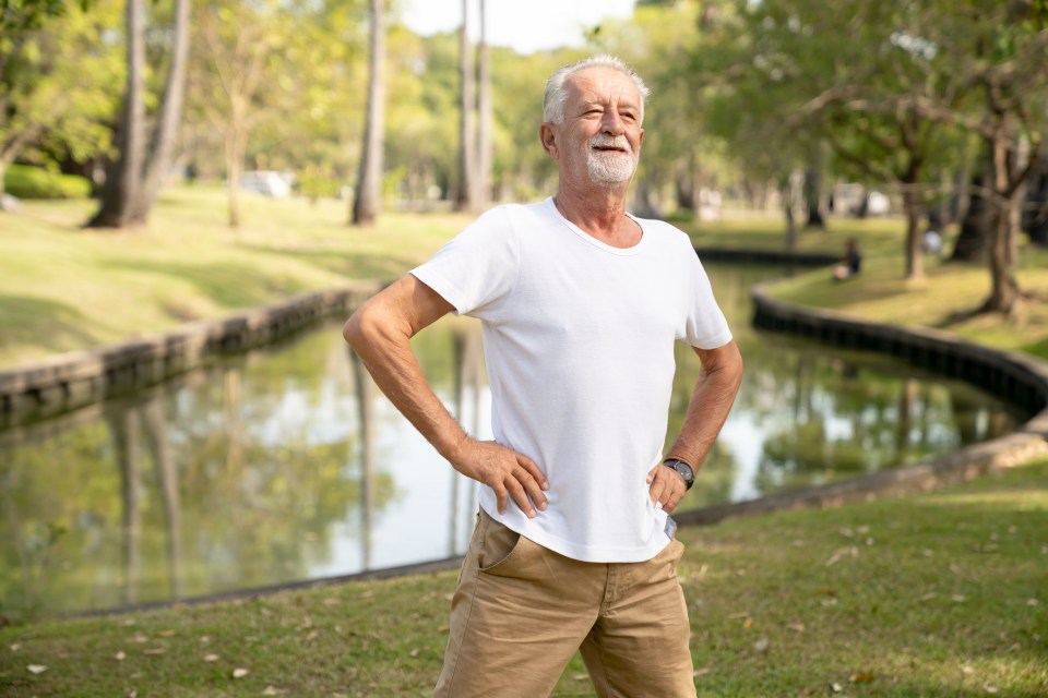Smiling senior man exercising in a park.