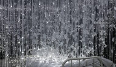 white glimmering tendrils dangle around a small twin bed