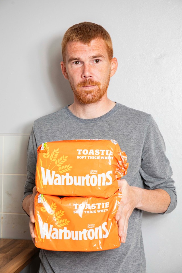 Man holding two loaves of Warburton's bread.