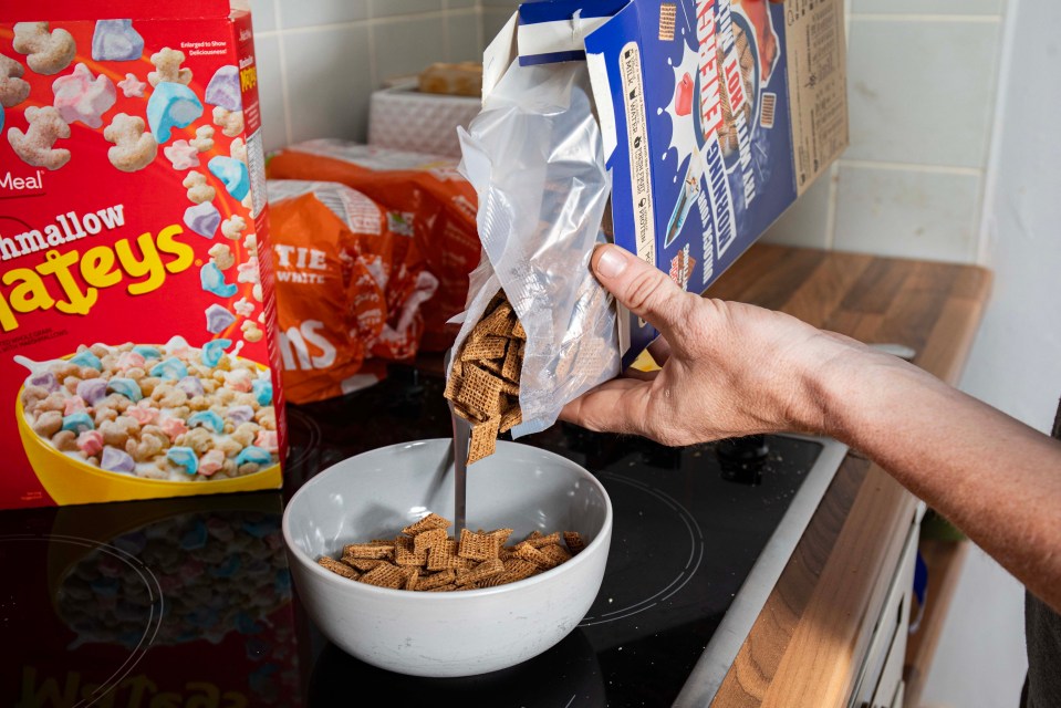 A person pouring cereal into a bowl.