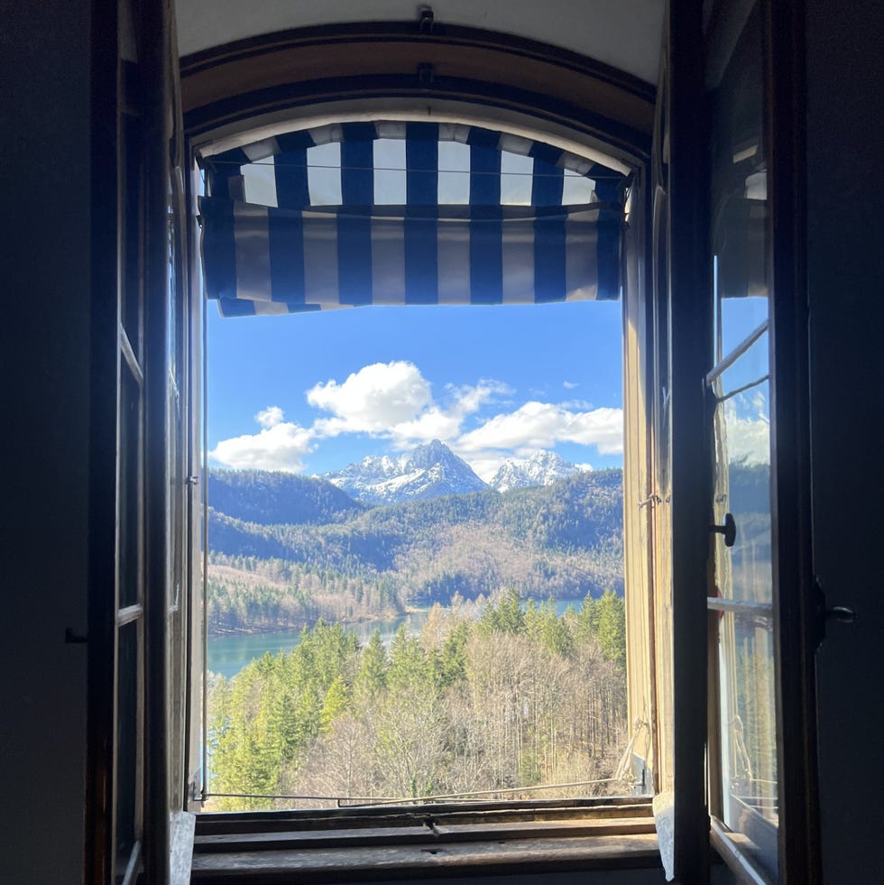 a window with a view of a mountain and trees