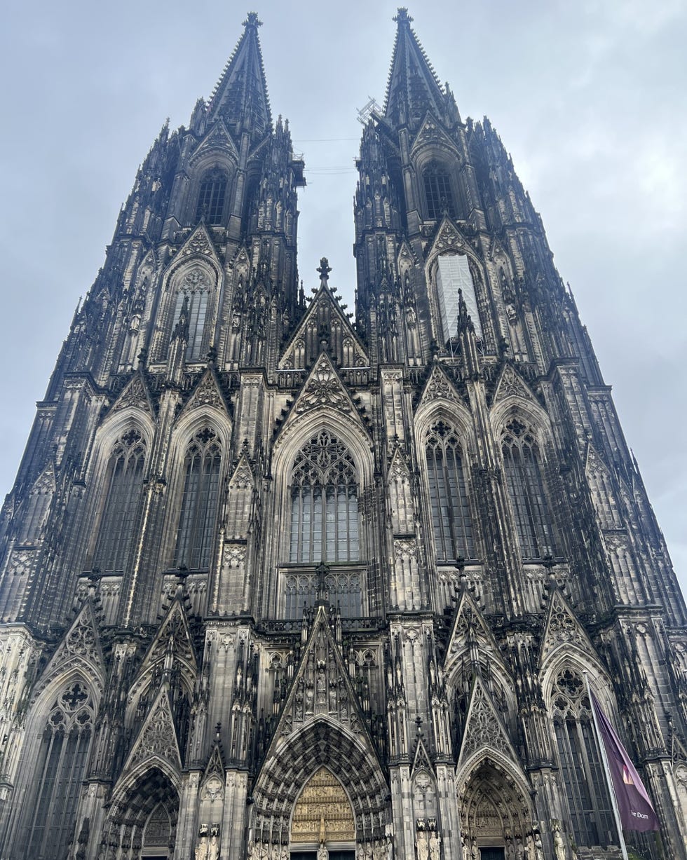 a large stone building with cologne cathedral in the background