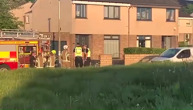 Firefighters and police officers at the scene of a torched van.