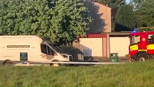 Burned-out van next to a firetruck.