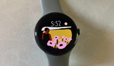 The Google Pixel Watch 3 on a white counter, showing the Vista watch face.
