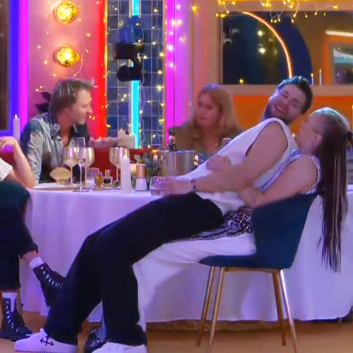 JoJo Siwa and Chris Hughes at a dinner table.