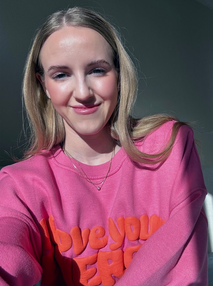 Woman in pink sweatshirt with "love you more" lettering.