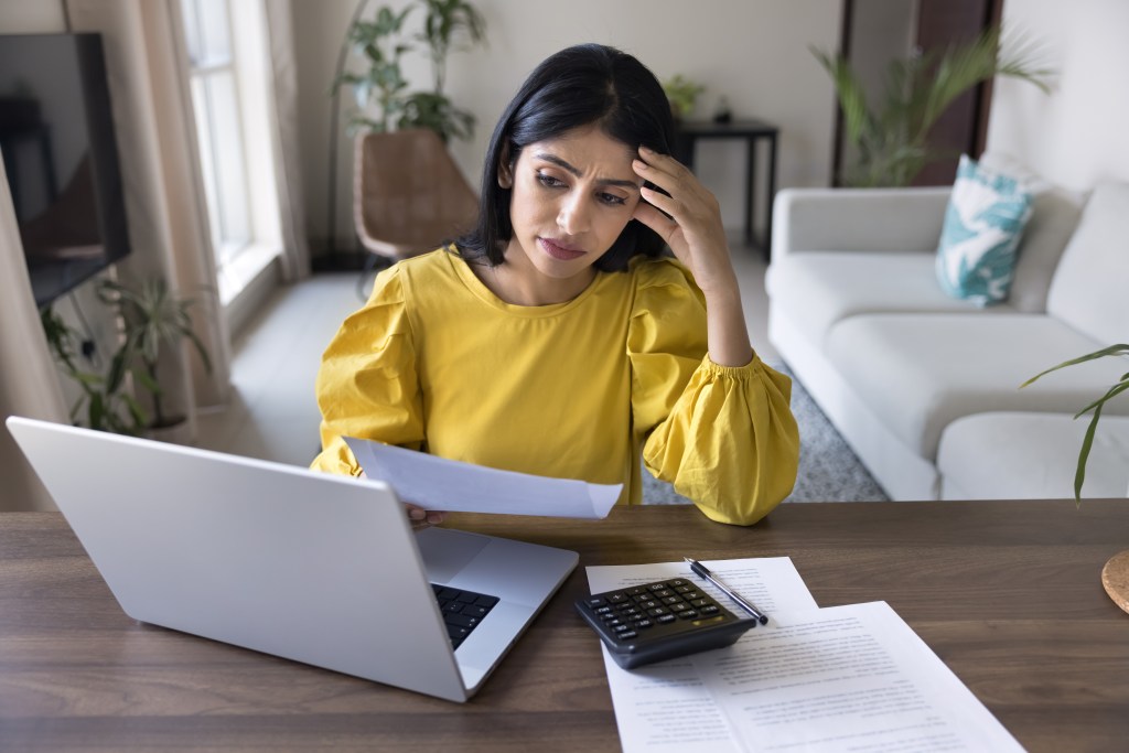 Young Indian woman looking stressed due to financial issues and unexpected high bills