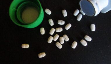Zyrtec tablets on a black surface next to open bottle and green cap.
