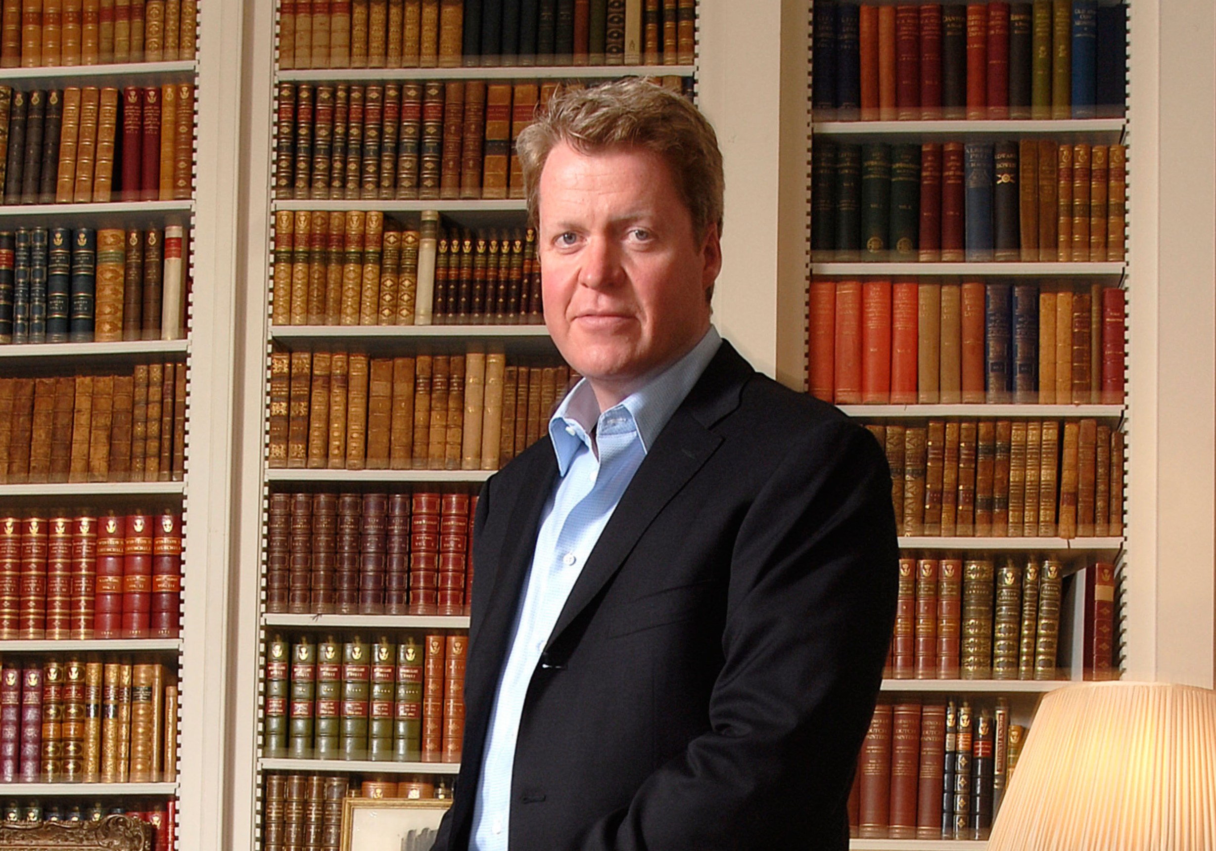 Earl Charles Spencer standing in a library at Althorp House.