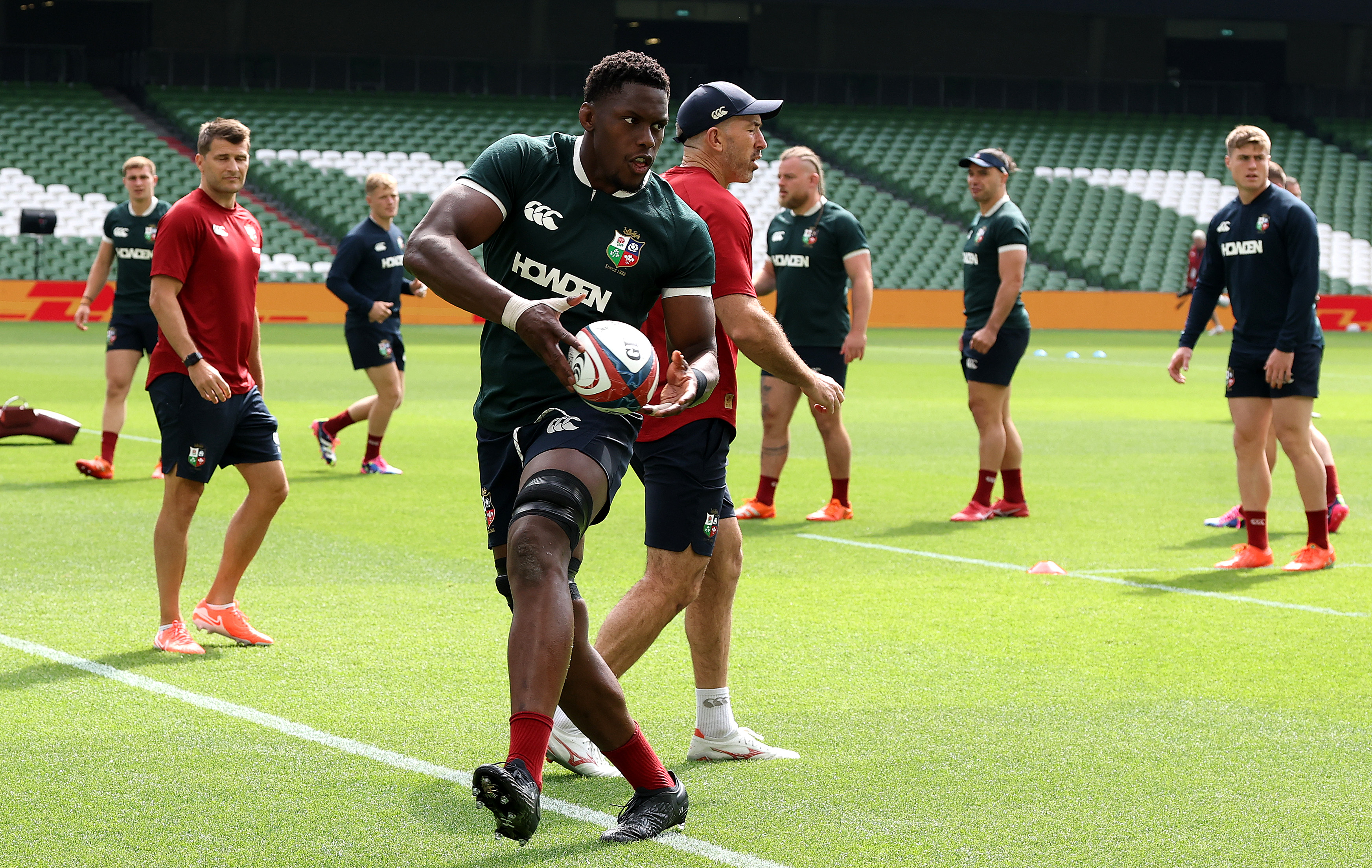 Maro Itoje passing a rugby ball during the British & Irish Lions Captain's Run.