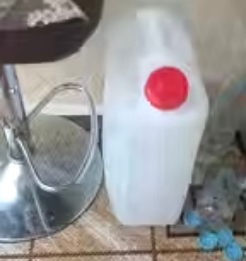 A large water jug on a floor.