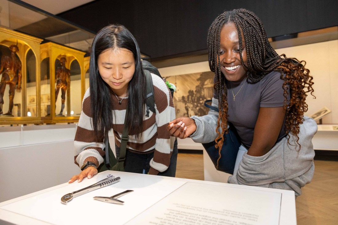 Two Northeastern students lean over an exhibit of medical tools at the Science Museum in London.