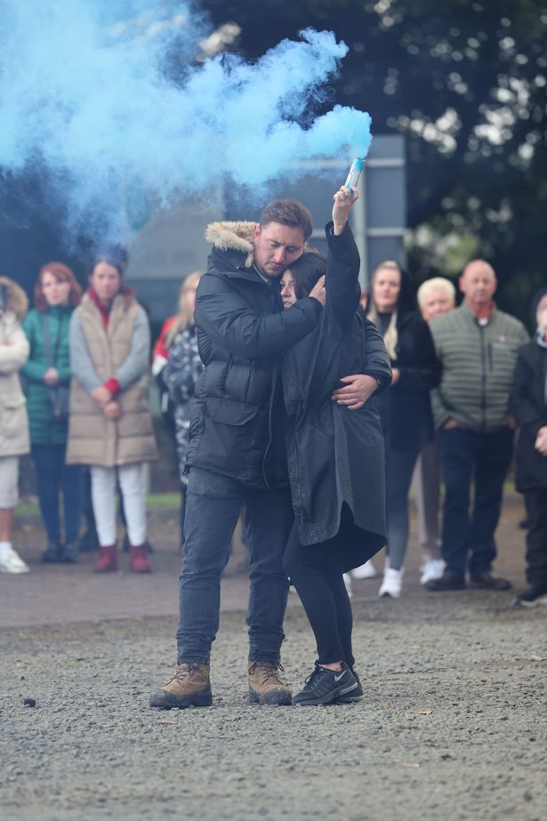 Cole Cooper's mother Wendy Stewart holds a flare at the vigil