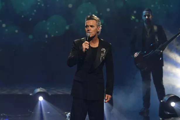 Robbie Williams performing on stage