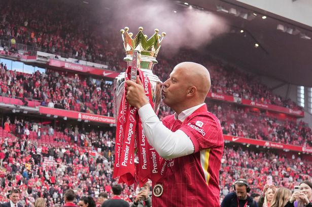 Liverpool's manager Arne Slot kisses the winner's trophy as he celebrates after the English Premier League soccer match between Liverpool and Crystal Palace at the Anfield stadium in Liverpool, England, Sunday, May 25, 2025. (AP Photo/Jon Super)