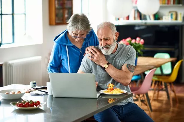 An older couple looking at their finances on a laptop