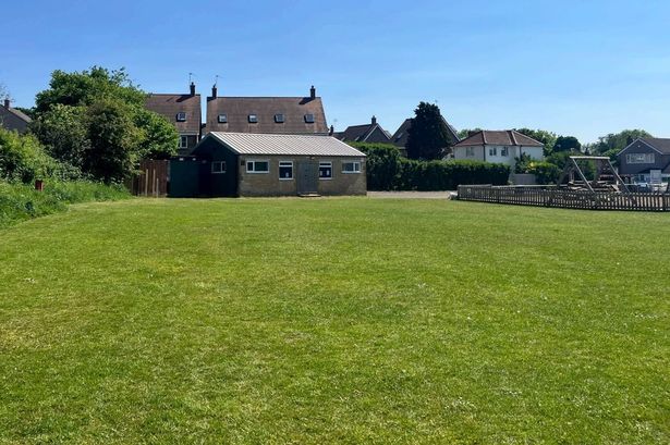 Single-storey building at the end of a large playing field