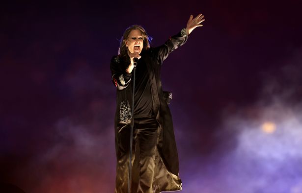 Ozzy Osbourne, in a black top, trousers and jacket, on stage in 2022.