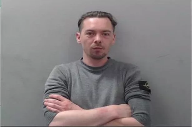 Aaron Thomas Curragh PSNI mugshot in grey top with dark hair 