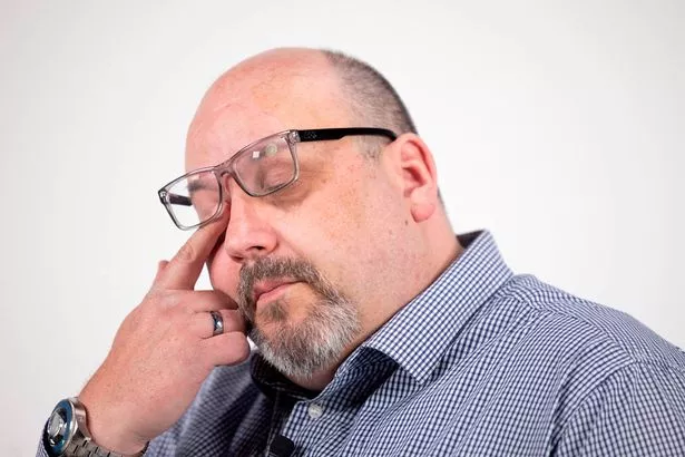 A man in a blue shirt crying