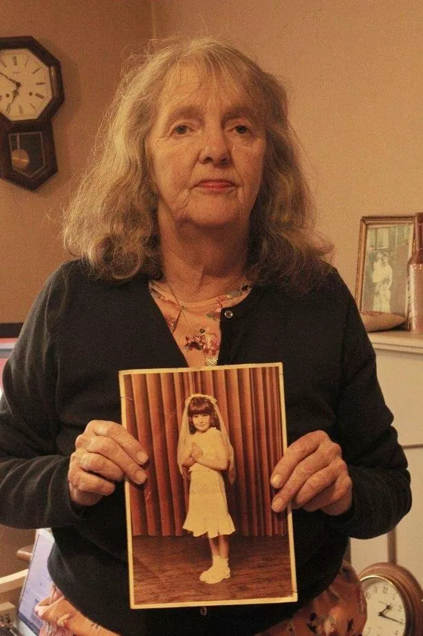 File photo of Joy Dove holding a photo of her daughter Jodey Whiting as a child