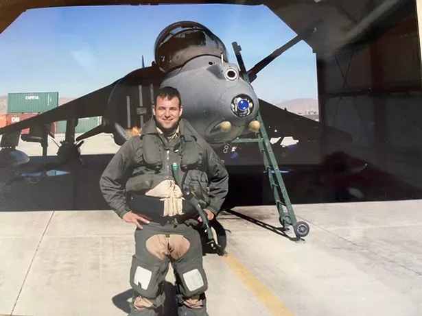 A man in front of a harrier jet