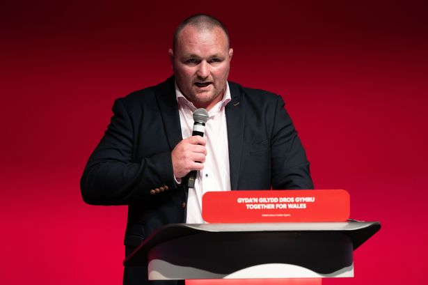 Former Welsh rugby player Ken Owens speaking at Welsh Labour conference holding a microphone to his mouth
